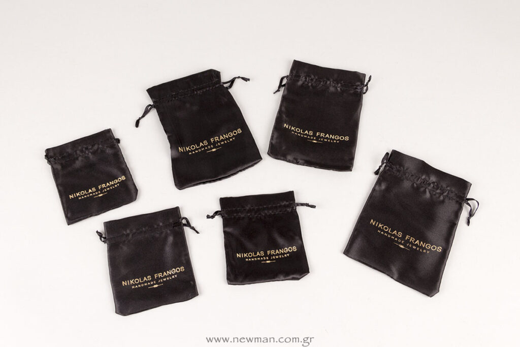 Nikolas Frangos gold logo on black satin pouches