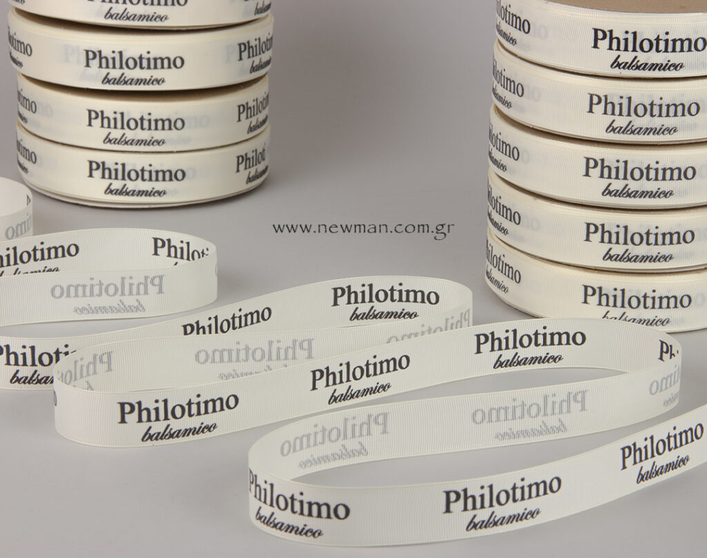 Εκρού κορδέλα γκρο με μαύρα γράμματα το λογότυπο “Philotimo balsamico”.