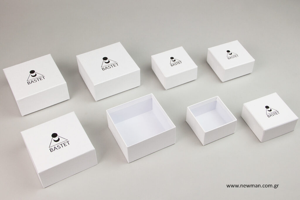 Tυπώσαμε με την ίδια τεχνική εκτύπωσης της μαύρης μεταλλοτυπίας την επωνυμία της εταιρείας (σύμβολο και όνομα) σε χάρτινα λευκά σαγρέ κουτιά με καπάκι.