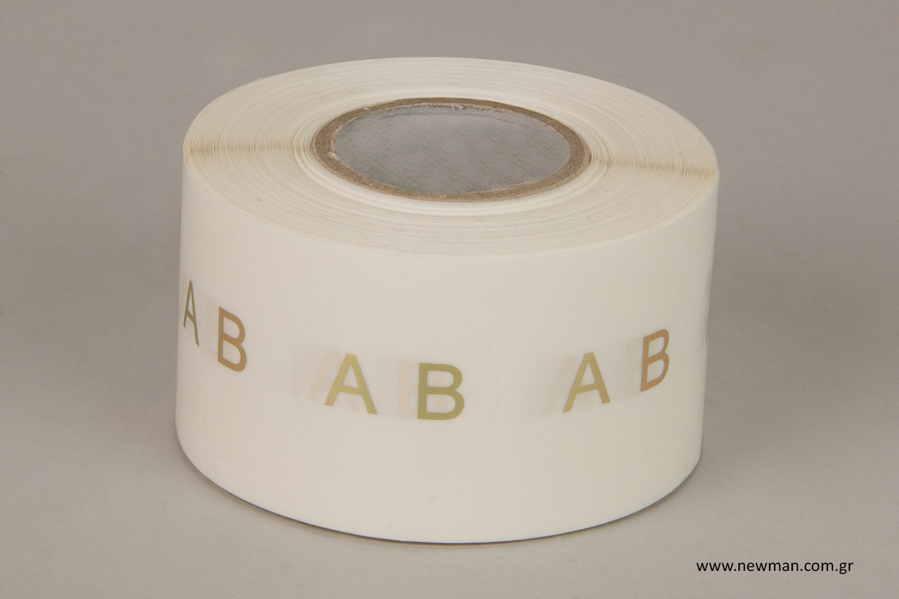 Round transparent sticky labels with gold printed letters.