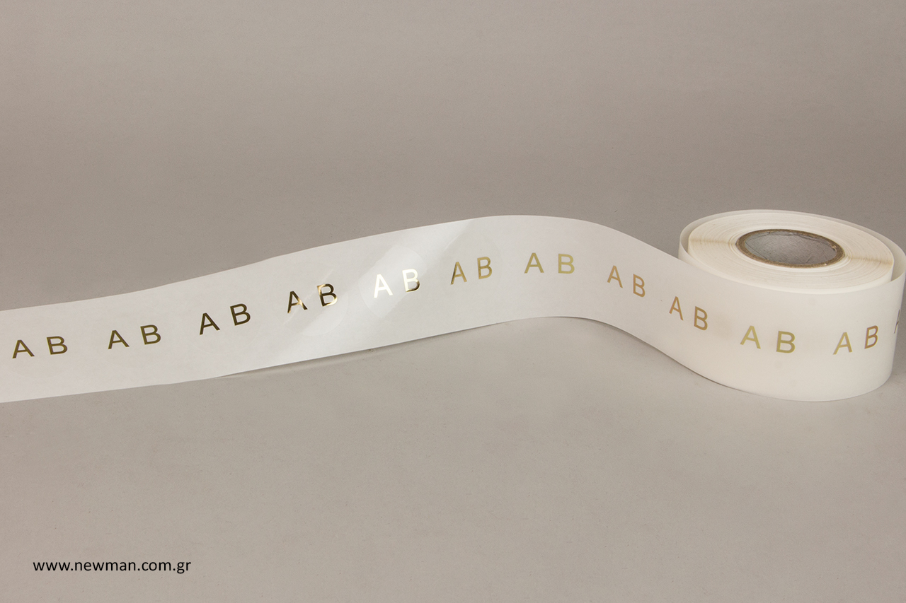 Self-adhesive labels with gold hot-foil printed monograms.