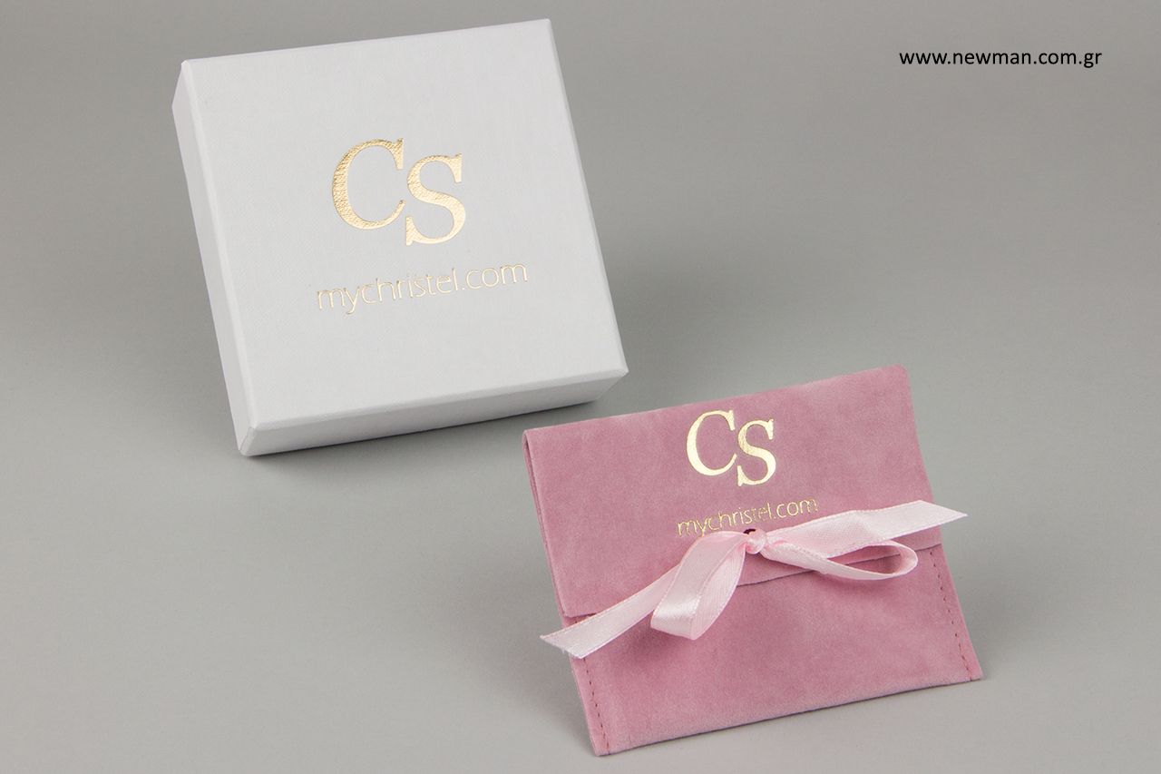 Paper boxes and suede pouches with gold hot-foil printing.