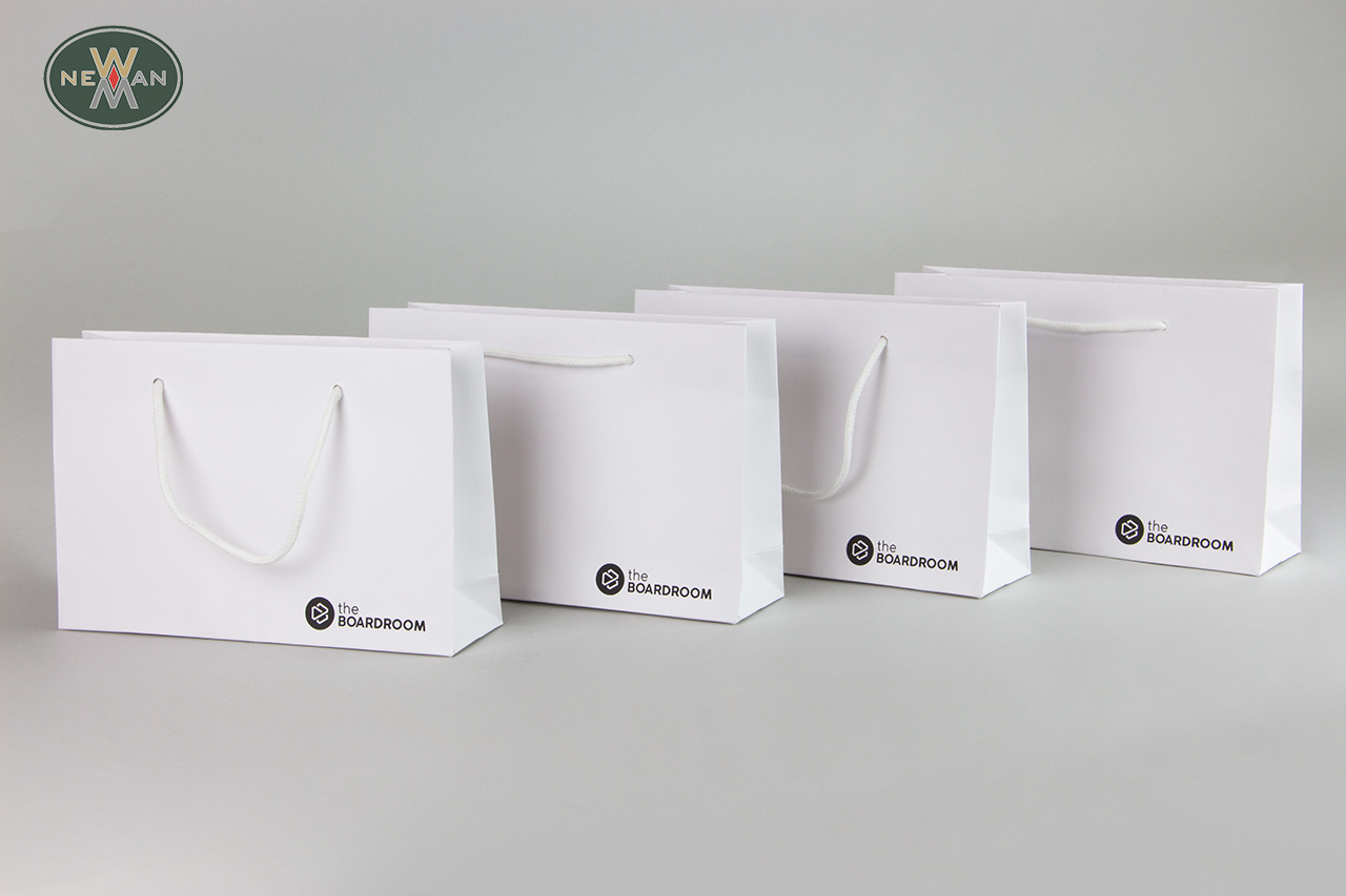White wholesale luxury paper bags with brand name printing.